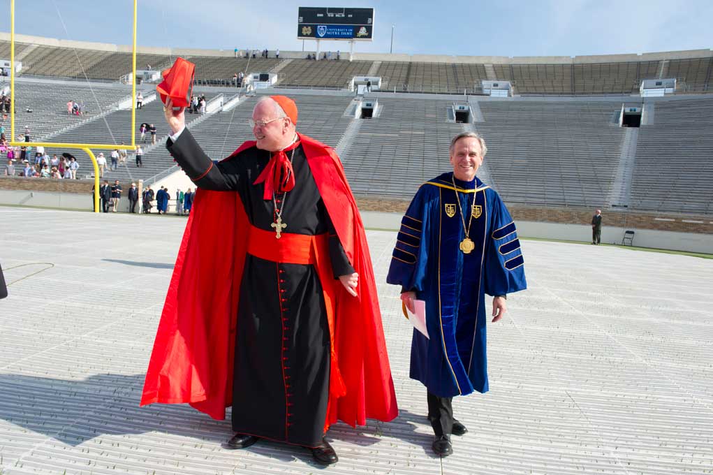 May 19, 2013; Timothy Cardinal Dolan, Archbishop of New York and Commencement speaker walks to the stage with Rev. John I. Jenkins, C.S.C., president of the University of Notre Dame before the 2013 Commencement ceremony in Notre Dame Stadium. Photo by Barbara Johnston/University of Notre Dame