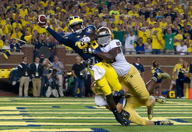 Sept. 7, 2013; Michigan Wolverines quarterback Devin Gardner (98) throws while being tackled by Notre Dame Fighting Irish linebacker Prince Shembo (55) and safety Austin Collinsworth (28) in the fourth quarter. Photo by Matt Cashore