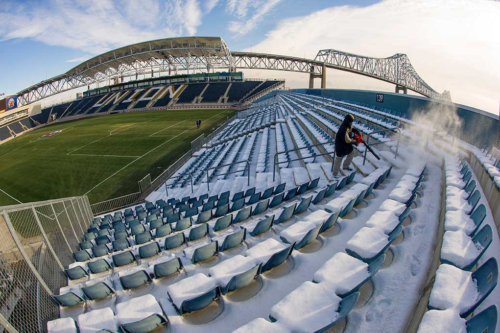 Dec 12, 2013; A stadium worker blows snow off the seats at PPL Park in Chester, Pa. Notre Dame men's soccer team will play against New Mexico tomorrow night in the semifinals of the NCAA Championship at the stadium. This season marks the program’s first appearance in the College Cup. Photo by Barbara Johnston/University Photographer