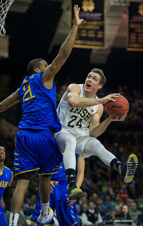 Dec. 7, 2013; Notre Dame guard Pat Connaughton goes up for a shot as Delaware forward Marvin King-Davis defends in the first half. Photo by Barbara Johnston/University of Notre Dame 