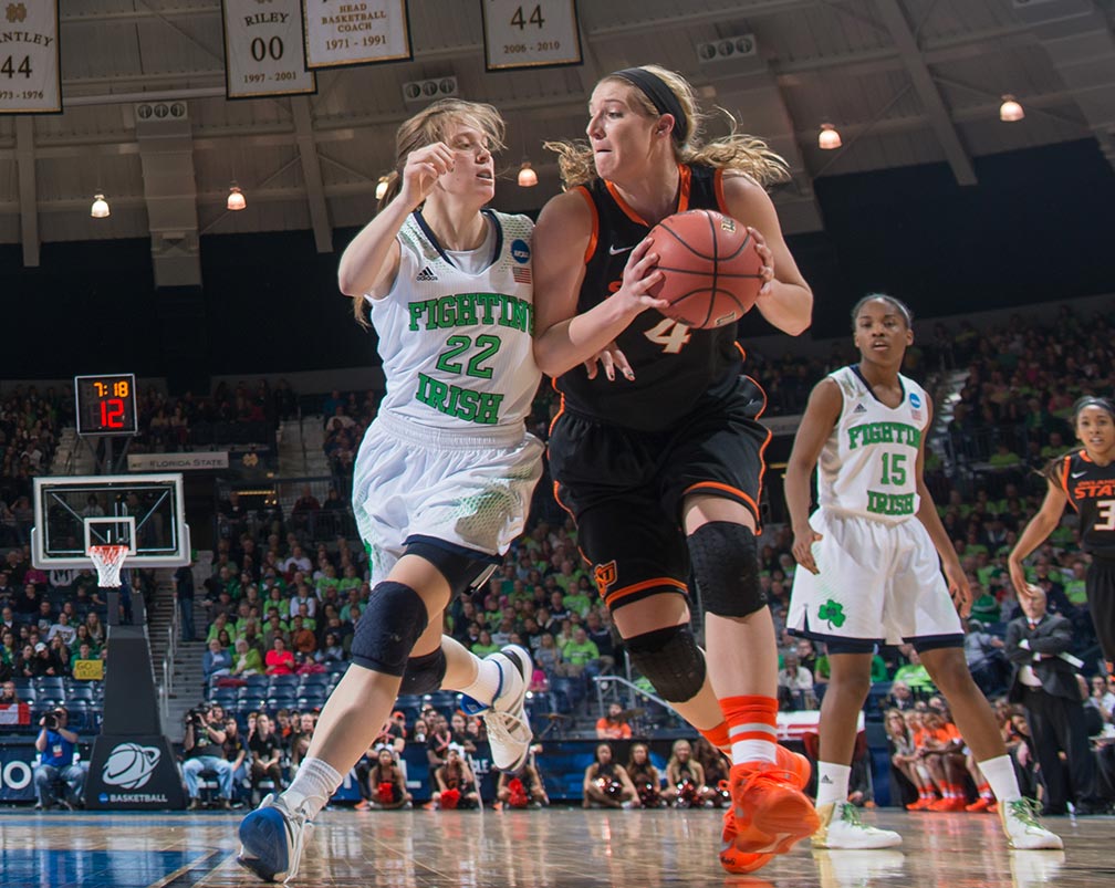 Mar 29, 2014; Oklahoma State Cowgirls forward Liz Donohoe (4) dribbles as Notre Dame Fighting Irish guard Madison Cable (22) defends in the regional semifinal game against Oklahoma State. Notre Dame won 89-72. 