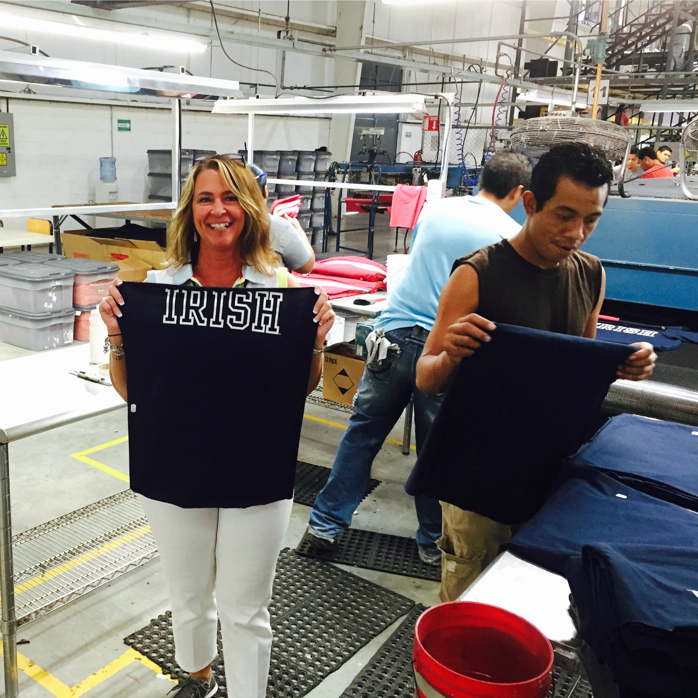 Tomi Gerhold with League factory workers as officially licensed Notre Dame shirts are made.