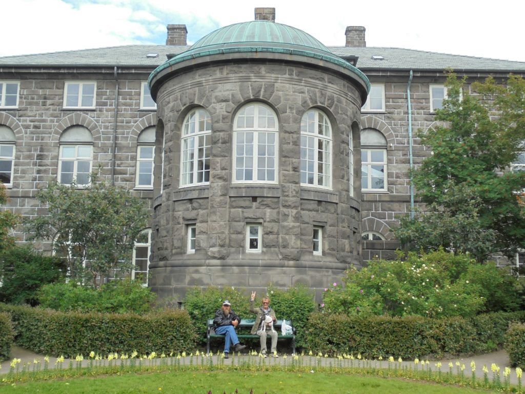 Two Icelanders sit in the garden behind the parliament building (Alþingi).