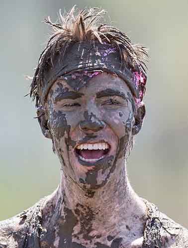April 26, 2015; Freshman Daniel Riley enjoys Muddy Sunday, a volleyball tournament played at White Field to support Habitat for Humanity. Photo by Barbara Johnston/University of Notre Dame